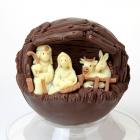 Sfera di cioccolato al latte con immagine della natività in rilievo in cioccolato bianco