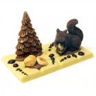 Didascalia: decorazione di cioccolato con alberello e scoiattolo su tavoletta di cioccolato 