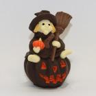 A fun little Halloween witch with a pumpkin in decorated white milk chocolate
