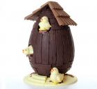 Uovo di Pasqua a forma di botte di legno e pulcini di cioccolato che lo usano come pollaio